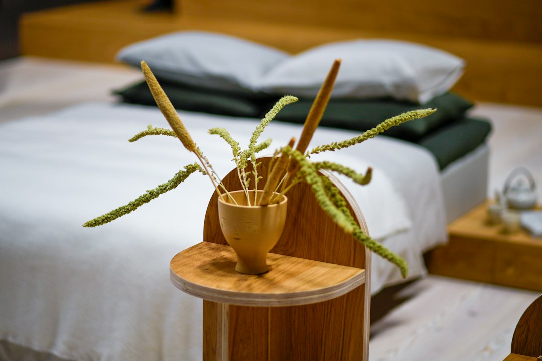 Dried grass in a wooden vase on a bedside table