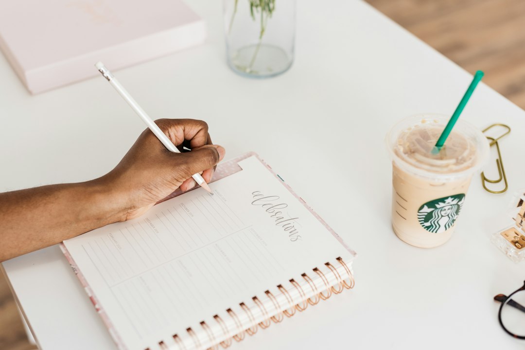 person writing on notebook