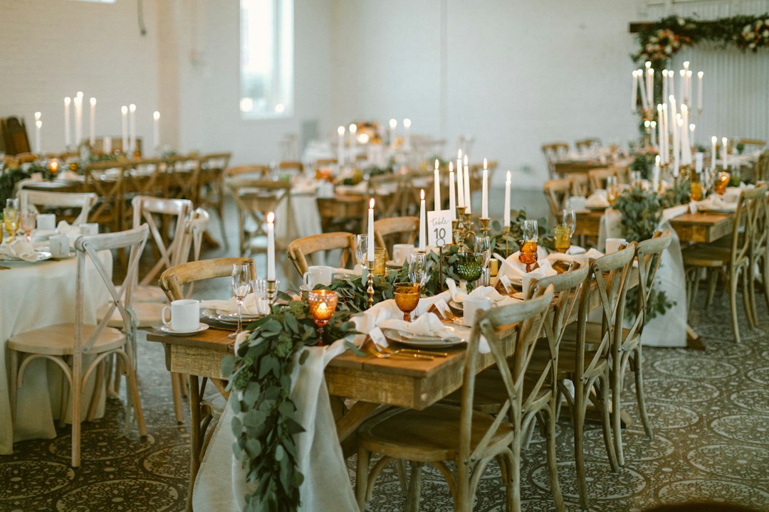 Wedding reception tables set with candles and greenery