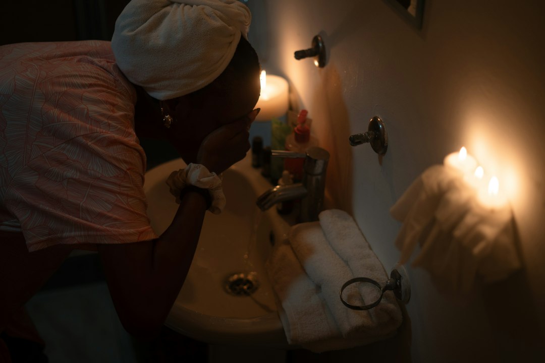 Woman washing her face by candlelight